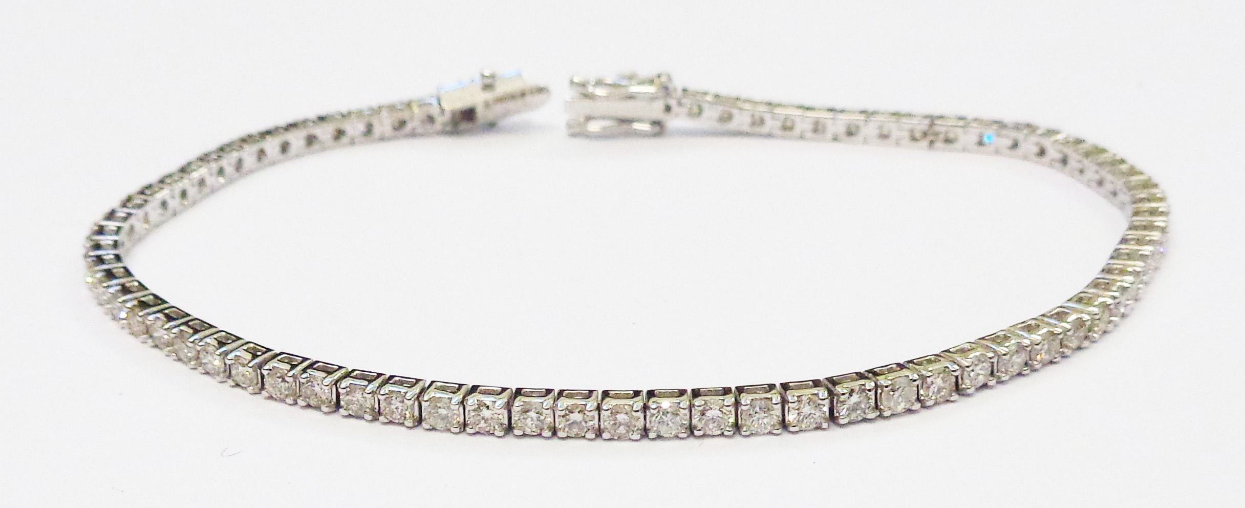 A marked 750 white metal bracelet, each of the links set with an individual brilliant cut