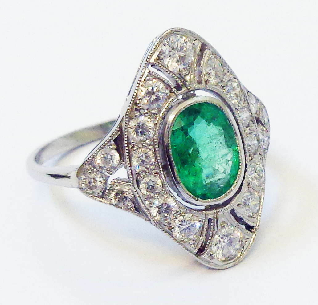 A marked PLAT 1920`s style oval panel ring, set with central oval emerald within a pierced diamond