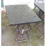 A patio table with cast iron Grover & Baker sewing machine base and reconstituted black marble top