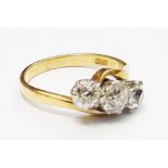 A marked 18ct. yellow metal three stone old cushion cut diamond cross-over ring - 1.75ct.TDW