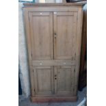 A 3' 6" Victorian waxed pine corner cupboard with canted sides and shelves enclosed by two pairs