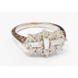 An import marked 750 white gold Art Deco style ring, set with three central baguette diamonds within