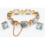 A yellow metal fancy link bracelet, set with seven large emerald cut topaz - sold with a