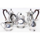 A silver five piece tea and coffee set of baluster form with ribbed lids and wooden scroll