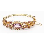 A hallmarked 375 gold Edwardian style clasp bracelet, set with central oval amethyst within a seed