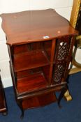 AN EDWARDIAN MAHOGANY TWO TIER REVOLVING BOOKCASE with fretwork detail on a base section with