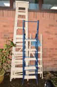 A COLLECTION OF CREAM PAINTED LADDERS, to include three wooden step ladders and metal frame step