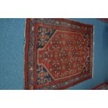 A 20TH CENTURY TURKISH WOOLLEN RED GROUND RUG, 194cm x 128cm, together with a Kashan style red