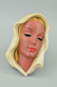 A GOLDSCHEIDER TERRACOTTA FACE MASK, modelled as a young woman's head wearing cream head scarf,
