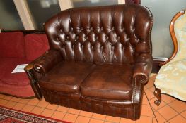 A BROWN BUTTONED LEATHER TWO SEATER SETTEE, approximate width 132cm
