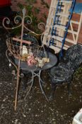 A SMALL ROUND METAL GARDEN TABLE with two black aluminium garden chairs, a wrought iron planter