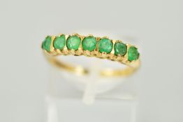 A 9CT GOLD SEVEN STONE EMERALD RING designed as a row of circular emeralds with a 9ct hallmark for