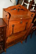 A SLIM ARTS AND CRAFTS OAK FALL FRONT BUREAU above a double cupboard section (key)