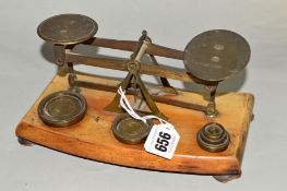 A SET OF POSTAL SCALES, with weights mounted on wooden plinth