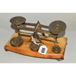 A SET OF POSTAL SCALES, with weights mounted on wooden plinth