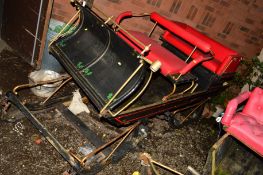 A VINTAGE TROIKA SLEIGH with two red upholstered seats on large casters, approximate width 114cm x