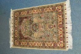 A 20TH CENTURY CAUCASIAN STYLE SILK RUG, cream ground with foliate detail and multi strap border,