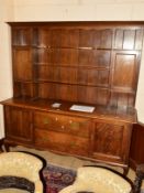 AN EARLY 20TH CENTURY OAK DRESSER, with three tier plate rack central to two cupboard doors above
