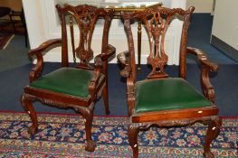 A PAIR OF REPRODUCTION CARVED MAHOGANY CHIPPENDALE STYLE ARMCHAIRS with green leatherette drop in