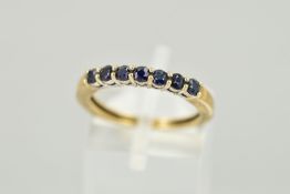 A 9CT GOLD SEVEN STONE SAPPHIRE RING, designed as a line of circular claw set sapphires, hallmark