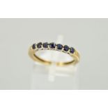 A 9CT GOLD SEVEN STONE SAPPHIRE RING, designed as a line of circular claw set sapphires, hallmark