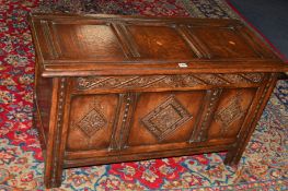 A REPRODUCTION CARVED OAK TRIPLE PANEL COFFER, approximate width 106cm x depth 47cm x height 61cm