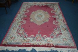 A 20TH CENTURY CHINESE WOOLLEN RUG, red and cream ground with foliate design, 274cm x 182cm