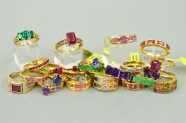 TWENTY FIVE MAINLY GEM SET GOLD PLATED RINGS to include a seven stone emerald ring, a three stone