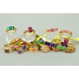 TWENTY FIVE MAINLY GEM SET GOLD PLATED RINGS to include a seven stone emerald ring, a three stone
