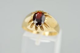 A 9CT GOLD RED PASTE SIGNET RING designed as an oval red paste within a claw setting to the