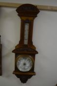 AN CARVED WALNUT ANEROID BAROMETER, with foliate moulding, approximate height 103cm