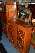 A REPRODUCTION YEW WOOD TWO DOOR BOOKCASE, together with a matching glazed corner cupboard (2) (