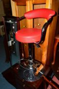 A PAIR OF MODERN CHROME FRAMED SWIVEL BAR STOOLS with red vinyl upholstery