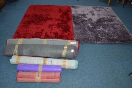 TWO MATCHING DUNELM RED GROUND RUGS, 160cm x 120cm, a similar violet rug, three other various rugs