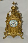 A BRASS FRENCH STYLE MANTEL CLOCK, printed enamel Roman numeral dial, on four scrolled feet,