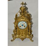 A BRASS FRENCH STYLE MANTEL CLOCK, printed enamel Roman numeral dial, on four scrolled feet,