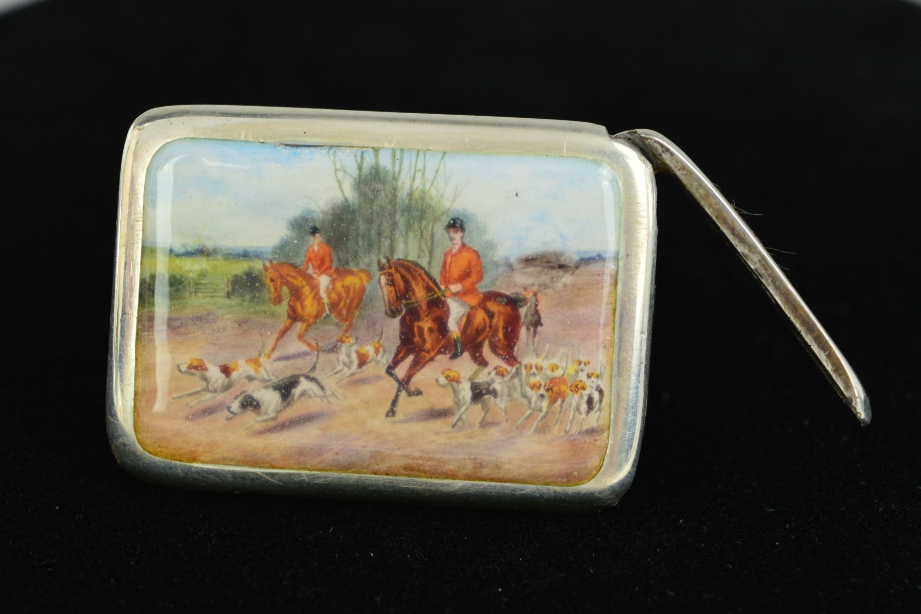 A LATE VICTORIAN SILVER AND ENAMELLED VESTA CASE, hinged opening end, the front with a hunting