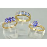 THREE 9CT GOLD TANZANITE DRESS RINGS to include a three stone oval mixed cut tanzanite with baguette