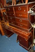 A REPRODUCTION MAHOGANY PEDESTAL DESK with tan leather inlay top and four various drawers, the right