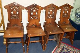 A SET OF FOUR 20TH CENTURY CARVED HARDWOOD GOTHIC CHAIRS with quatrefoil detail to the back and base