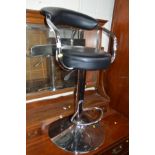 A MODERN CHROME FRAMED SWIVEL BAR STOOL