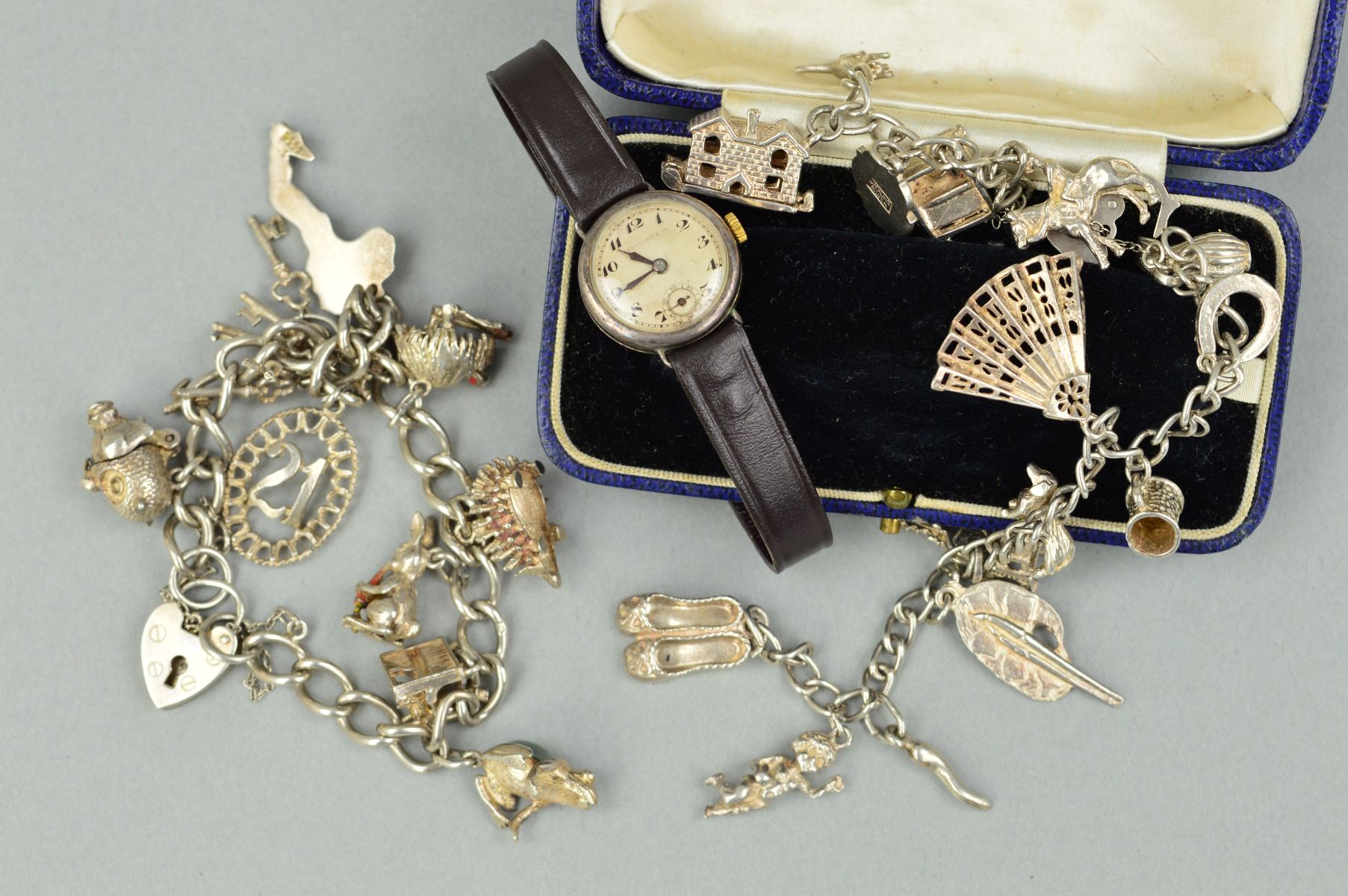 TWO CHARM BRACELETS AND A WATCH WITH ANTIQUE CASE, the charm bracelets on curb link chains