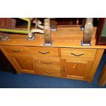 A MODERN LIGHT OAK SIDEBOARD with five various drawers and double cupboard doors, width 138cm x