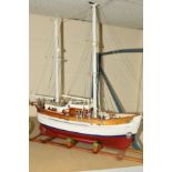 A WOODEN SCRATCH BUILT MODEL OF A FISHING VESSEL painted red and white on a wooden stand,