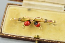 AN EARLY 20TH CENTURY GOLD BAR BROOCH, designed with two enamelled berries to the bar brooch,
