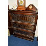 AN OAK LEAD GLAZED THREE SECTION BOOKCASE with fall front doors, width 87cm x depth 27cm x height