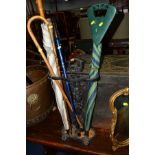 A PAINTED CAST IRON UMBRELLA STAND with contents