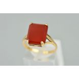 A CARNELIAN RING, designed as a rectangular carnelian within a four claw setting to the open