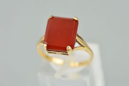 A CARNELIAN RING, designed as a rectangular carnelian within a four claw setting to the open