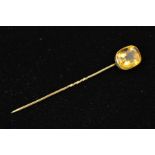 A CITRINE STICKPIN, designed as a rectangular citrine within a collet setting, length 80mm, weight